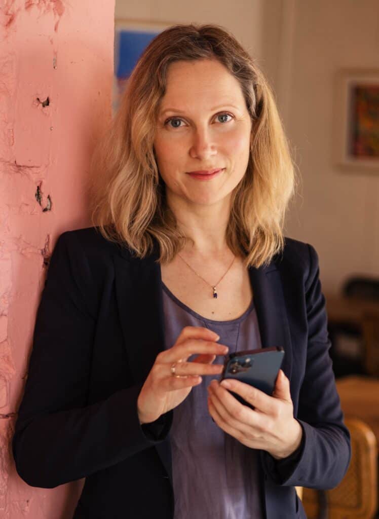 Professional woman using smartphone at work, representing business consulting and advisory services.
