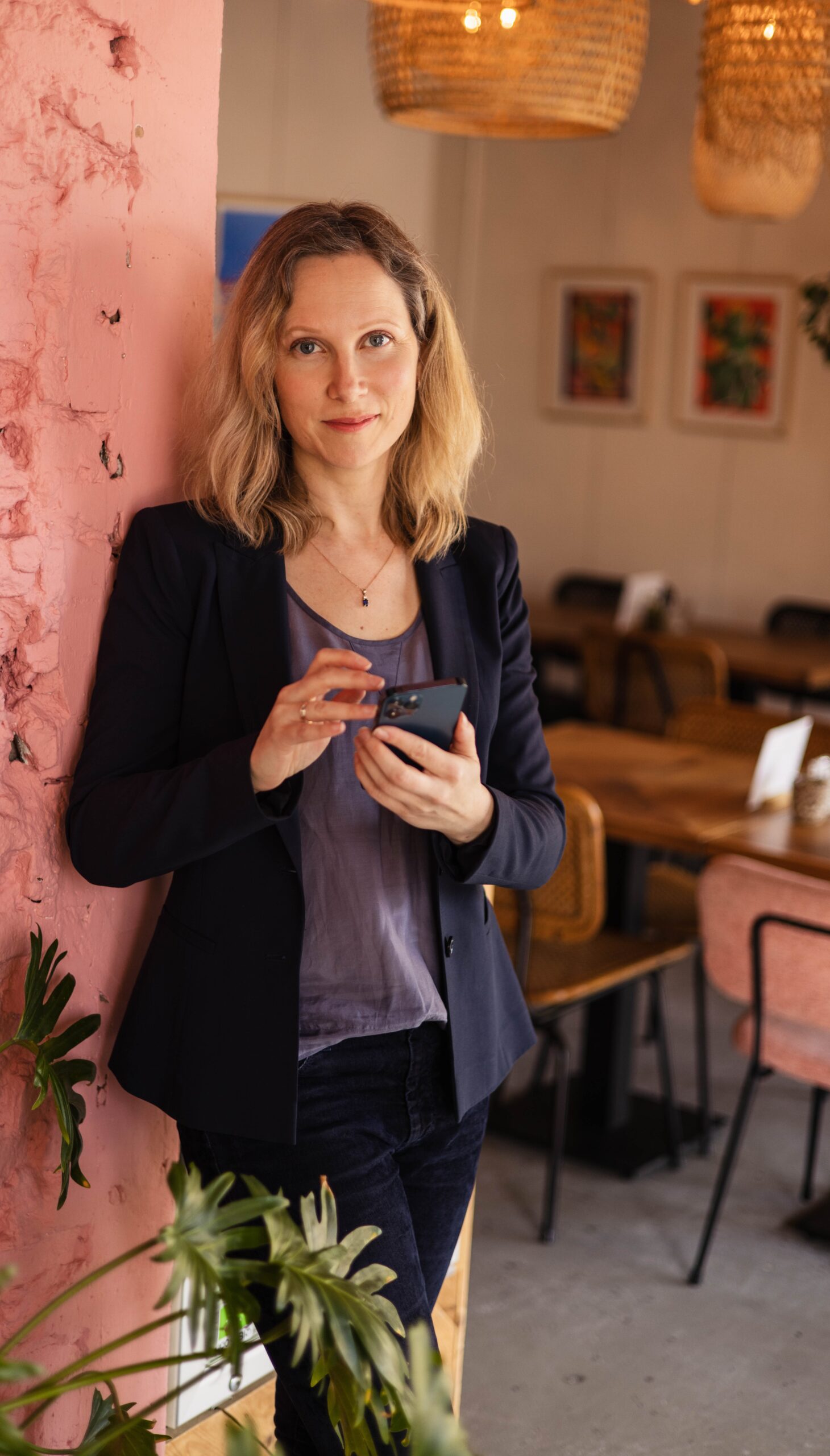 Professional woman using smartphone in cosy cafe - Business consulting and digital communication.